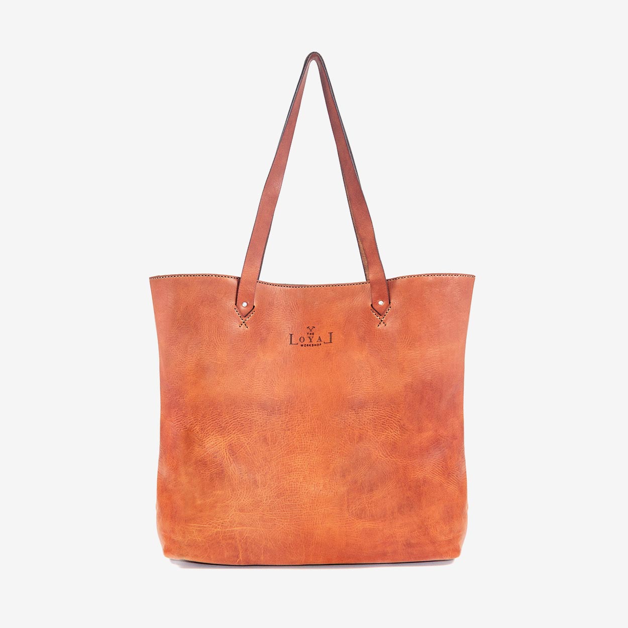 A large caramel brown handmade leather tote bag with hand stitching and etched logo detailing